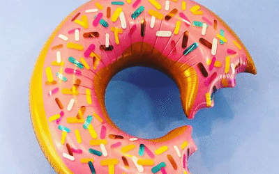 Donut balloon with a bite out of it with a blue background
