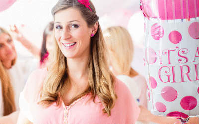 A woman with a pink and white new baby balloon